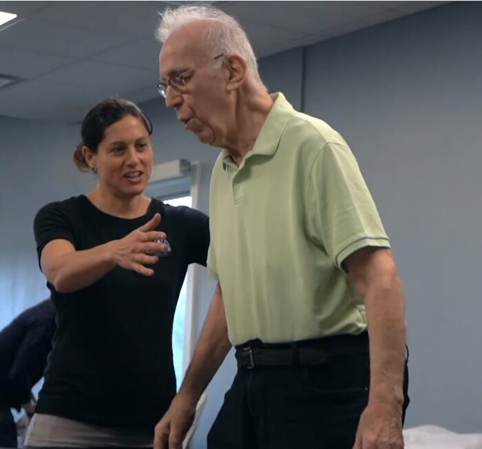 Physical therapist cueing an older adult through gait and standing balance training