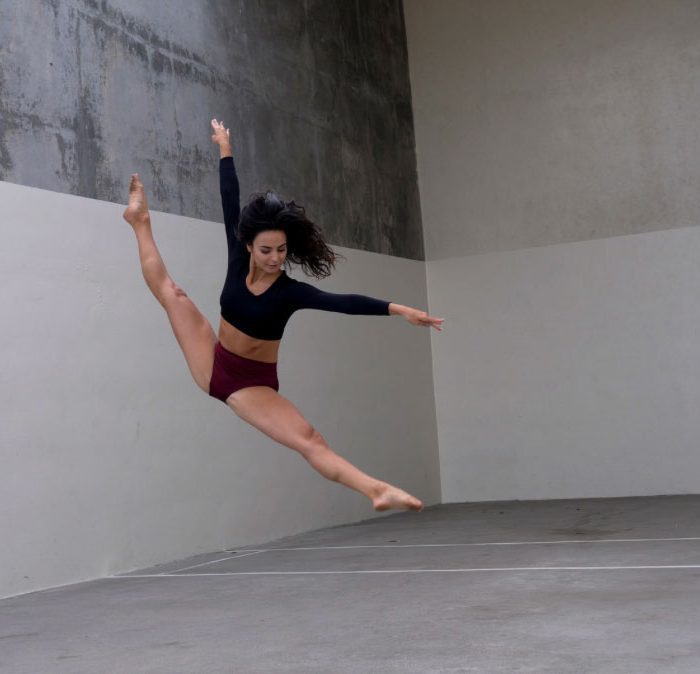 Dancer performing a mid-air leap in full extension